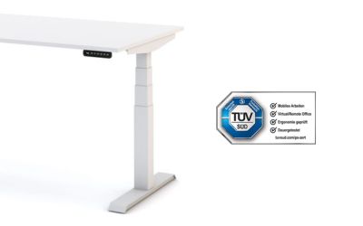 Ein weißer höhenverstellbarer Familien-Schreibtisch Modell ASSMANN Pitino mit elektronischem Bedienfeld. Neben dem Tisch ist das TÜV SÜD Zertifikat zu sehen.