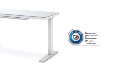 Ein weißer höhenverstellbarer Schreibtisch, das kompakte Modell ASSMANN Vindaro mit elektronischem Bedienfeld und Glasplatte. Neben dem Tisch ist das TÜV SÜD Zertifikat zu sehen.