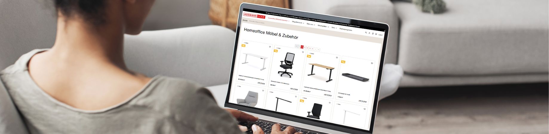Frau surft in Online-Shop für Homeoffice-Möbel und Zubehör auf einem Laptop im Wohnzimmer