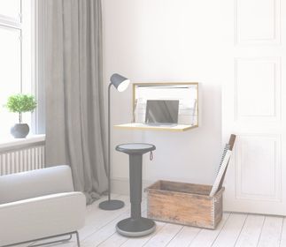Ein moderner Raum mit einem Arbeitsplatz, einem Laptop, einem Stehlampe, einem Hocker und einer Holzbox.