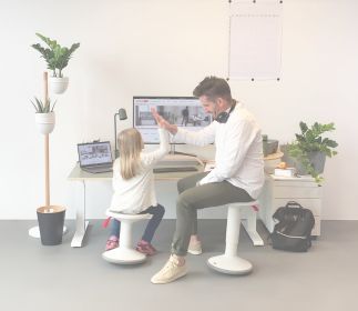 Ein Erwachsener und ein Kind in einem modernen Büro, die sich die Hände geben.