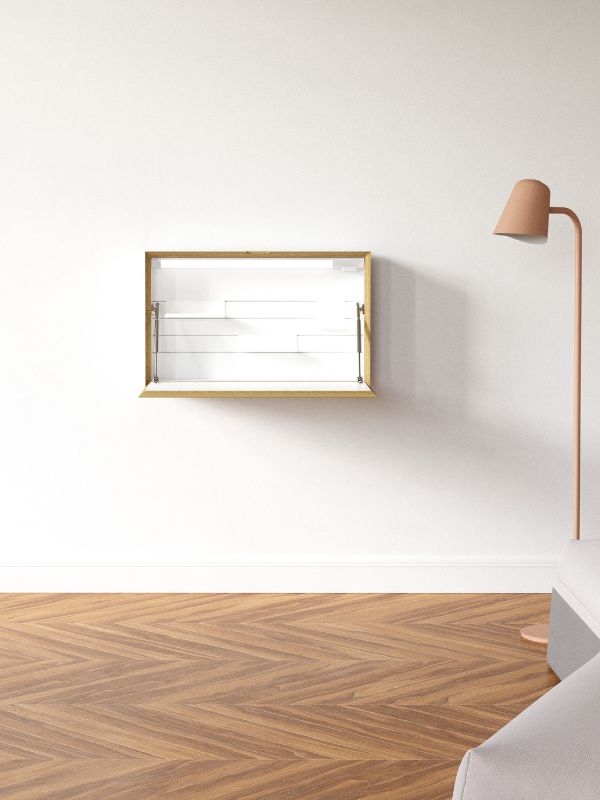 Ein Wandregal mit goldener Umrandung und weißen Regalböden, neben einer modernen Stehlampe.