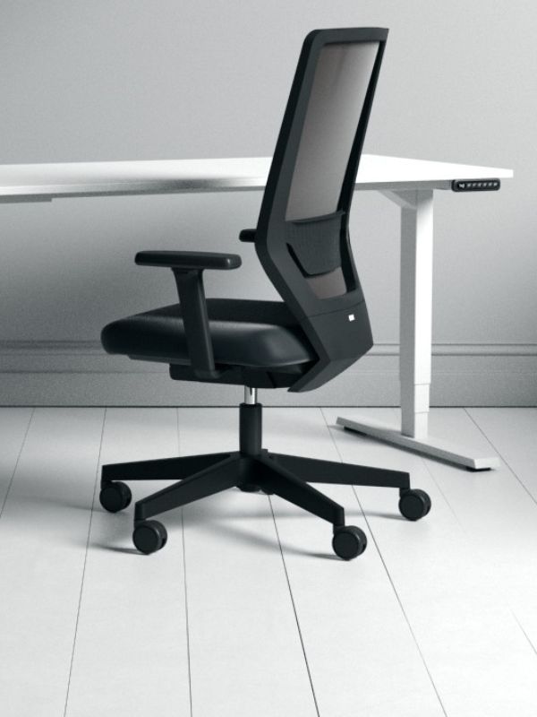 Schwarzer ergonomischer Bürostuhl mit Netzrückenlehne an weißem Schreibtisch